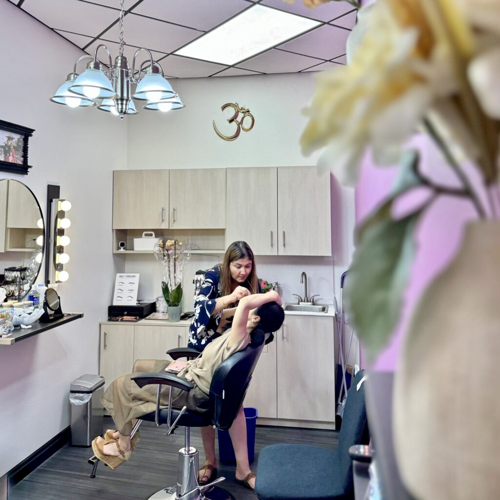 Wide view of Manisha threading a client&rsquo;s eyebrows at A&A Threading